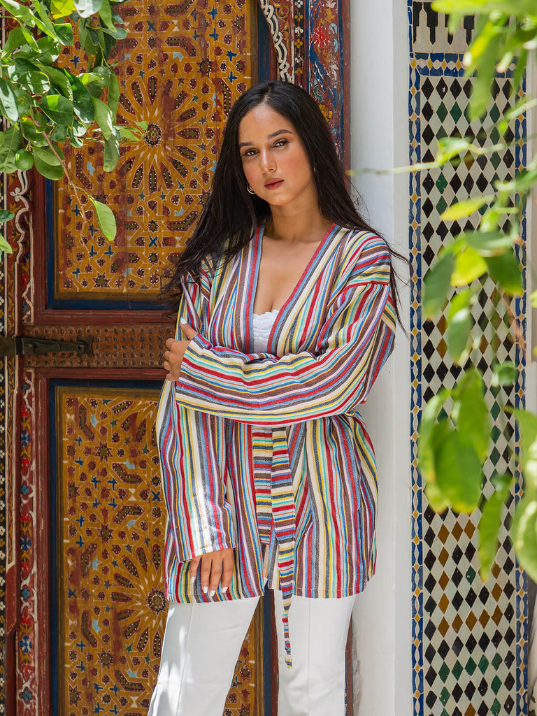 Model wearing Bohemia Design handwoven cotton jacket in rainbow stripe at Moroccan riad