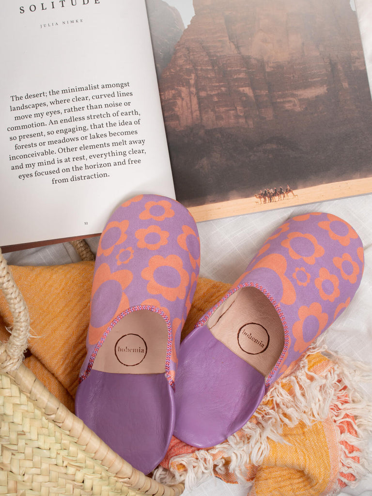 Margot Floral Babouche Slippers in Basket beside a travel magazine.