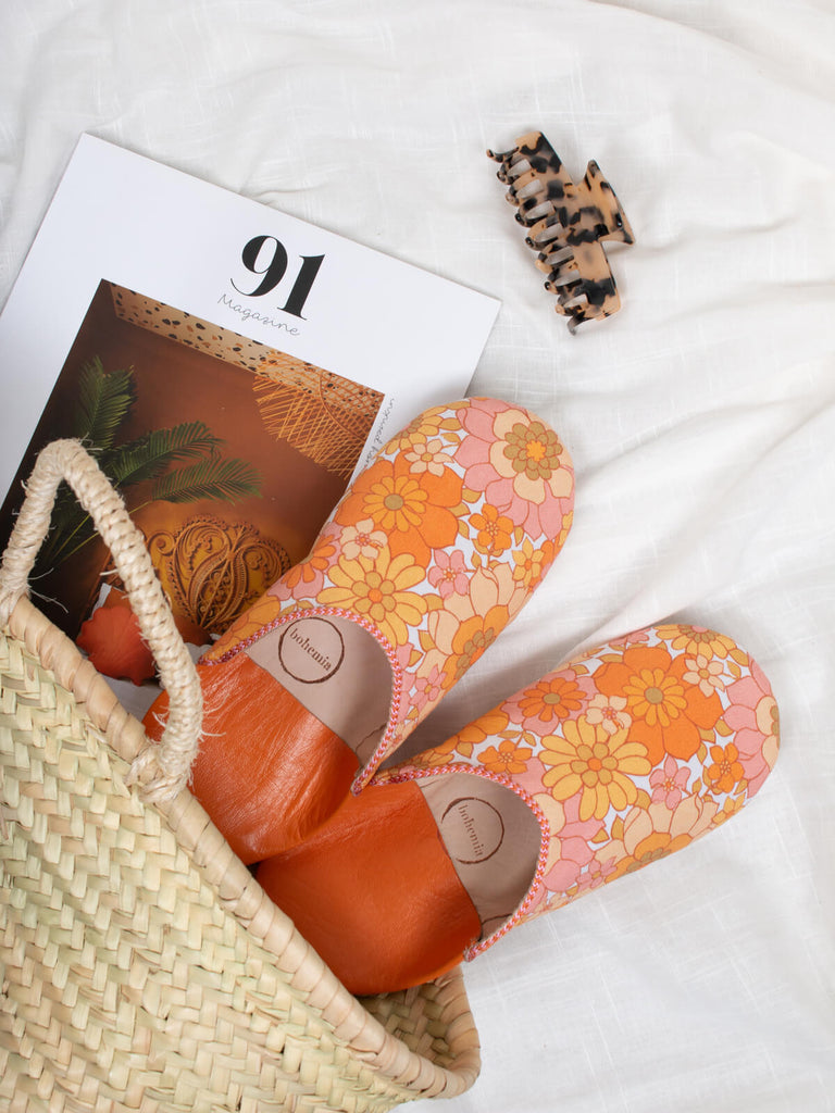 Margot Floral Babouche Slippers in a Bohemia Basket with a magazine.
