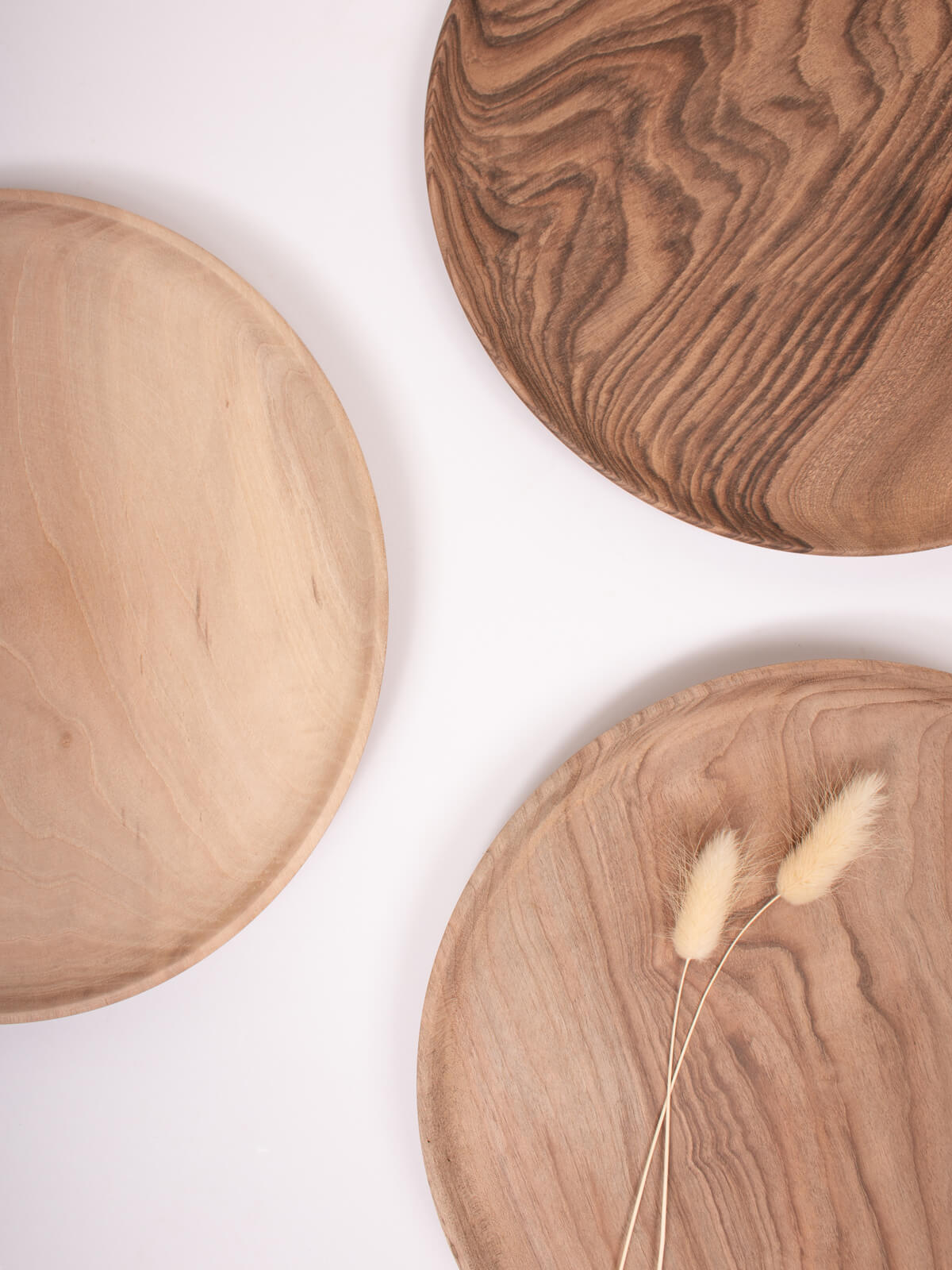 Three medium Walnut Wood Plates with a few strands of bunny tail grass 