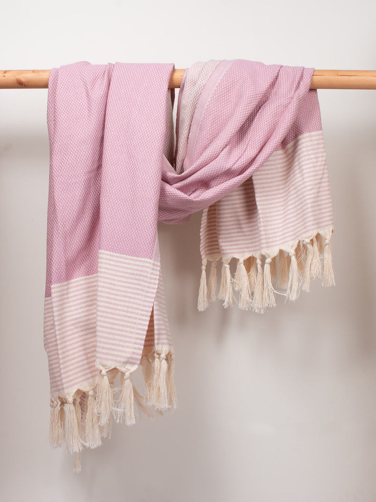 Striped Amalfi Hammam Towel in vintage pink stripe by Bohemia Design hanging on a wooden rod