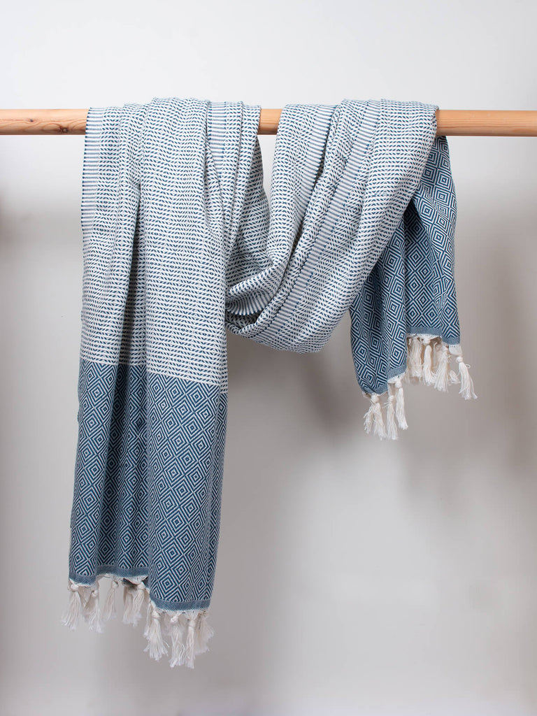 Nordic Dot Hammam Towel in indigo diamond pattern by Bohemia Design hanging on a wooden rod