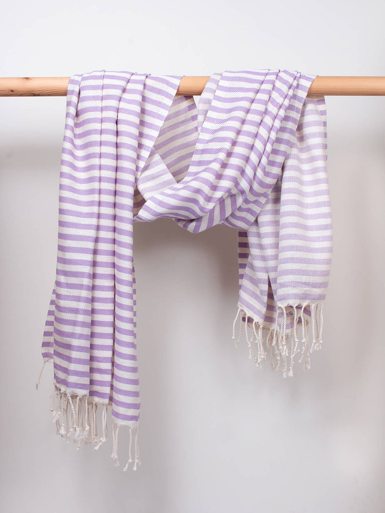 Striped Sorrento Hammam Towel in lilac stripe by Bohemia Design hanging on a wooden rod