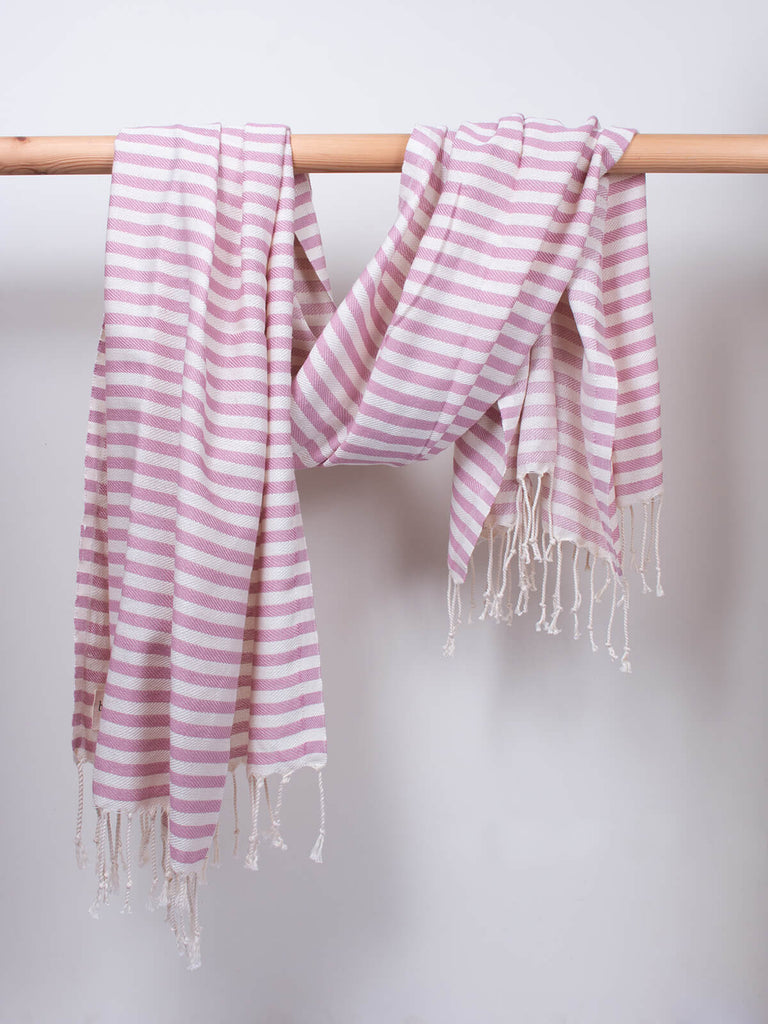 Striped Sorrento Hammam Towel in vintage pink stripe by Bohemia Design hanging on a wooden rod