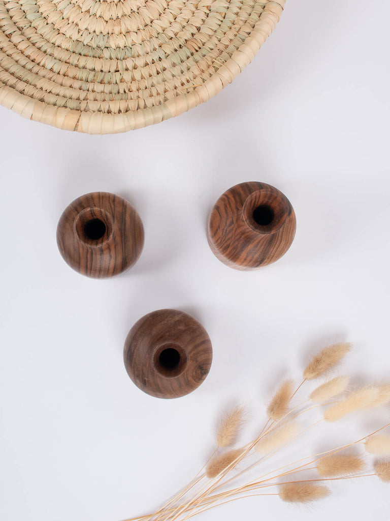 Set of three mini walnut wood vases by Bohemia Design with dried flowers and a palm leaf plate